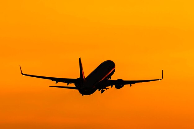 Airplane flying in sky during sunset