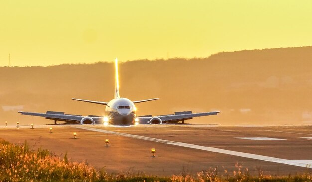 Airplane flying in sky at sunset