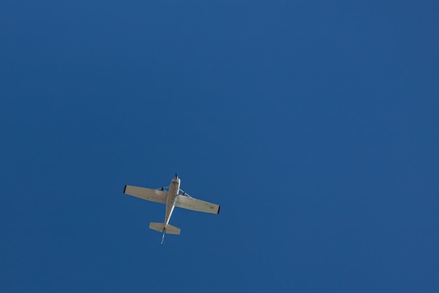 青い空と白い雲の下を飛んでいる飛行機