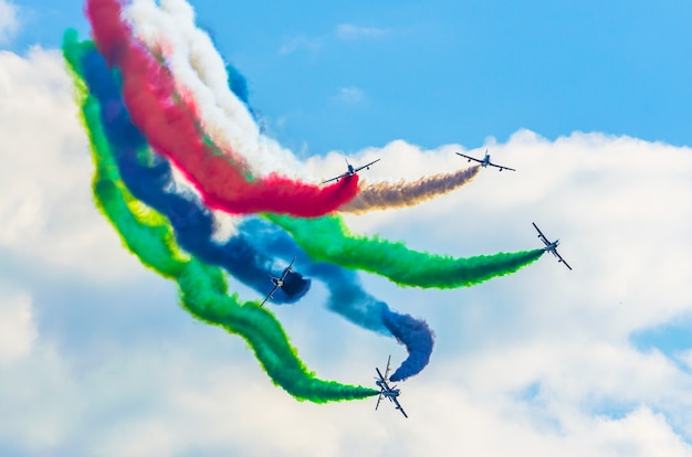 色の煙を背景にした飛行機のグループ戦闘機。