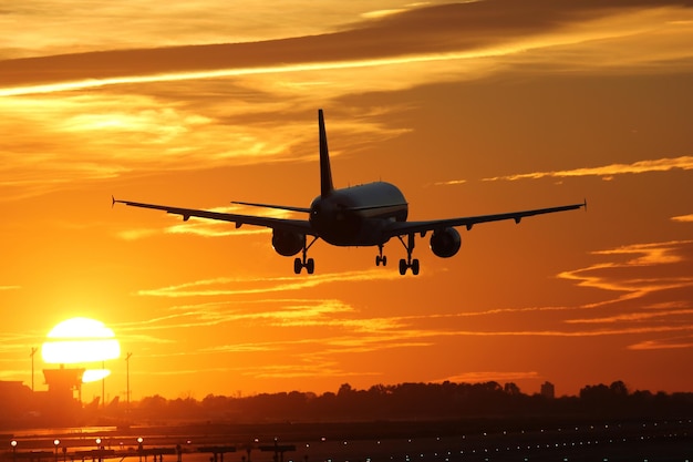 Airplane landing at an airport during sunset