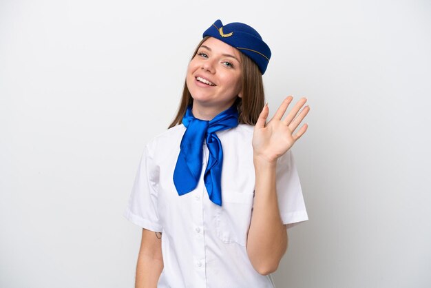 幸せな表情で手で敬礼する白い背景で隔離の飛行機リトアニアの女性スチュワーデス