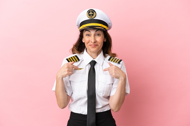 Airplane middle aged pilot woman isolated on pink background with surprise facial expression