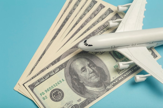 Airplane and money plane on the background of usa dollars the cost of travel air tickets and flights...