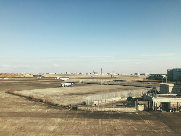 写真 空港の滑走路に乗った飛行機が晴れた空を眺めている
