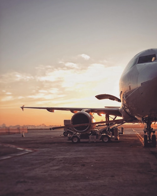 写真 夕暮れの空に向かって滑走路に乗った飛行機