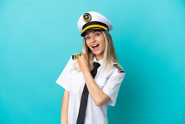 Airplane pilot over isolated blue background celebrating a victory