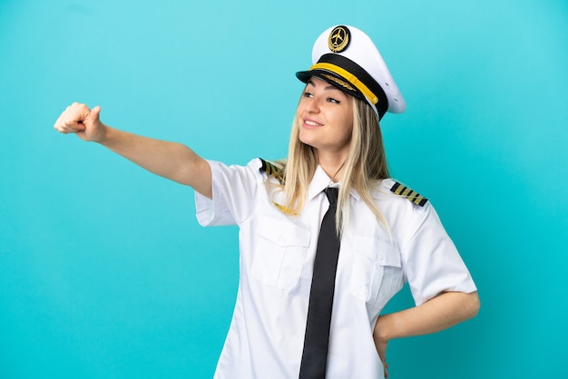 Airplane pilot over isolated blue background giving a thumbs up gesture