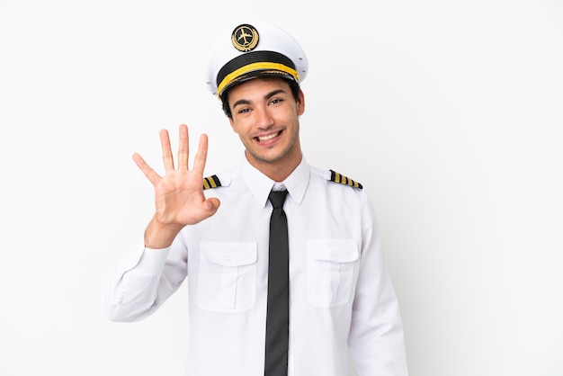 Пилот самолета на изолированном белом фоне счастлив и считает четыре пальцами