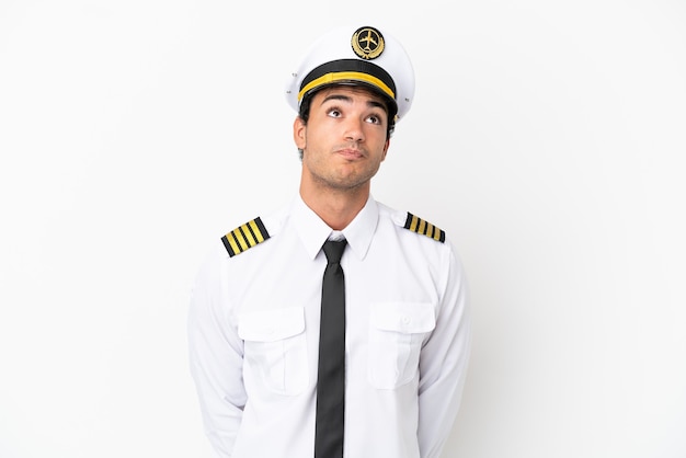 Airplane pilot over isolated white background and looking up