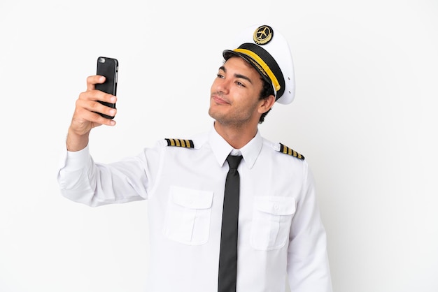 Airplane pilot over isolated white background making a selfie