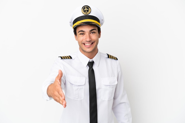 Airplane pilot over isolated white background shaking hands for closing a good deal