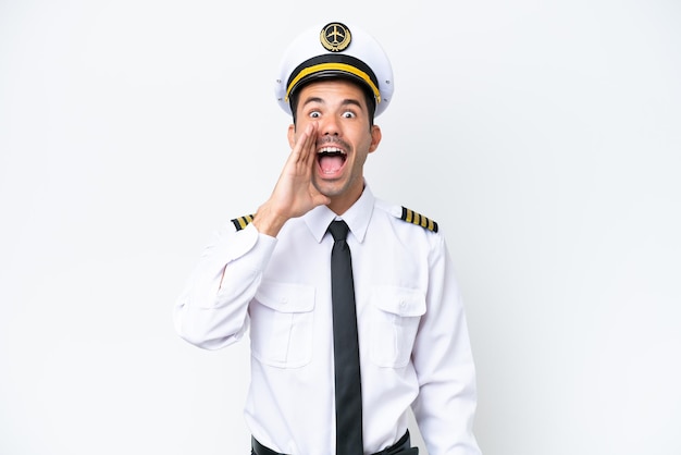 Airplane pilot over isolated white background shouting with mouth wide open