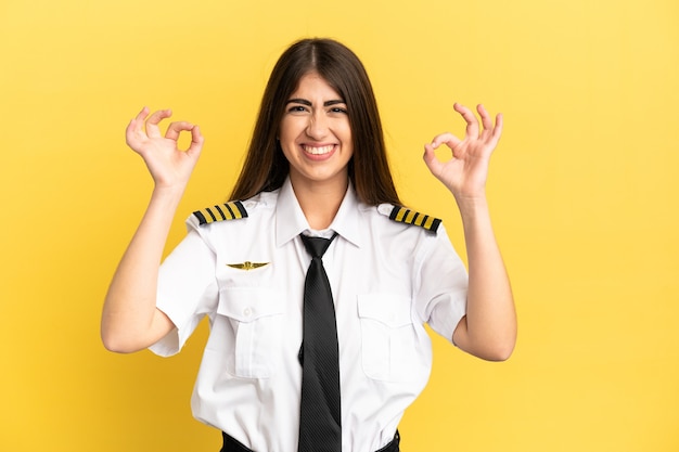 Airplane pilot isolated on yellow background in zen pose