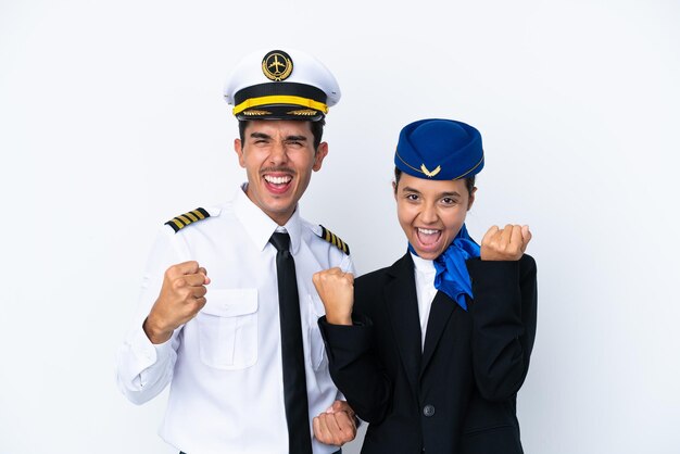 Pilota di aeroplani e hostess di razza mista isolati su sfondo bianco per celebrare una vittoria