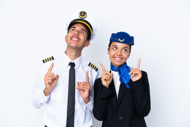 Airplane pilot and mixed race air hostess isolated on white background pointing with the index finger a great idea