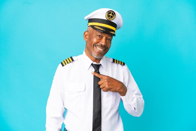 Airplane pilot senior man isolated on blue background with surprise facial expression