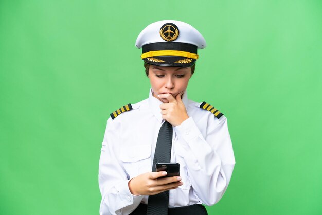 Airplane pilot woman over isolated chroma key background thinking and sending a message