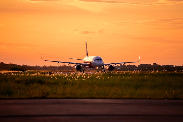 airplane running on taxi way at sunset.