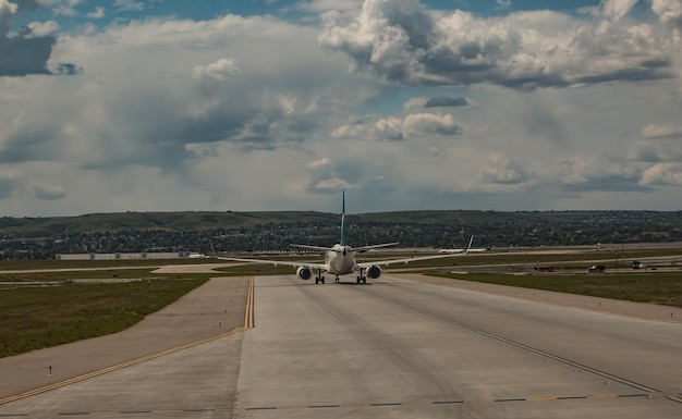 Photo airplane on runway against cloudy sky