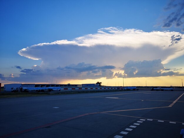 Airplane on runway against sky during sunset