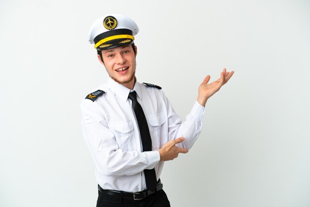 Airplane Russian pilot isolated on white background extending hands to the side for inviting to come