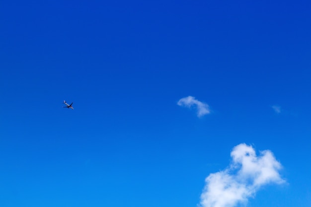 Foto aeroplano nel cielo su cielo blu e nuvole bianche.