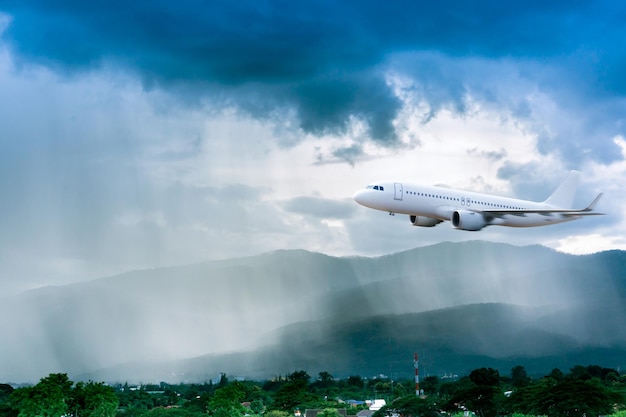 Airplane in the sky with rain over mountain The plane flies in terrible thunderstormConcept of climate weather