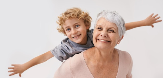 Airplane smile and portrait of grandmother with child embrace happy and bond on wall background Love face and senior woman with grandchild having fun playing piggyback and enjoying game together