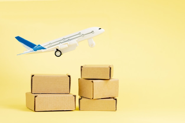 Airplane and stack of cardboard boxes. concept of air cargo and parcels, airmail. Fast delivery of goods and products. Cargo aircraft