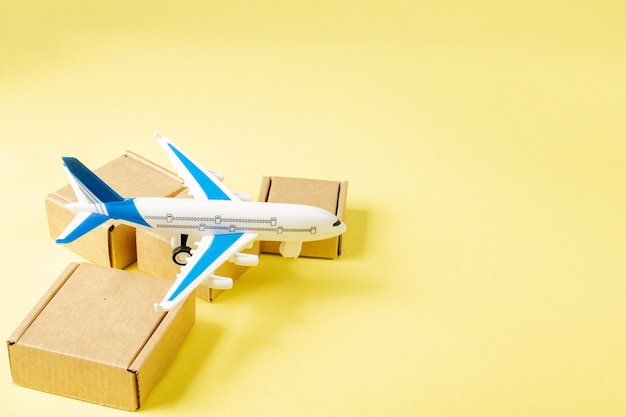 Airplane and stack of cardboard boxes. concept of air cargo and parcels, airmail. Fast delivery of goods and products.