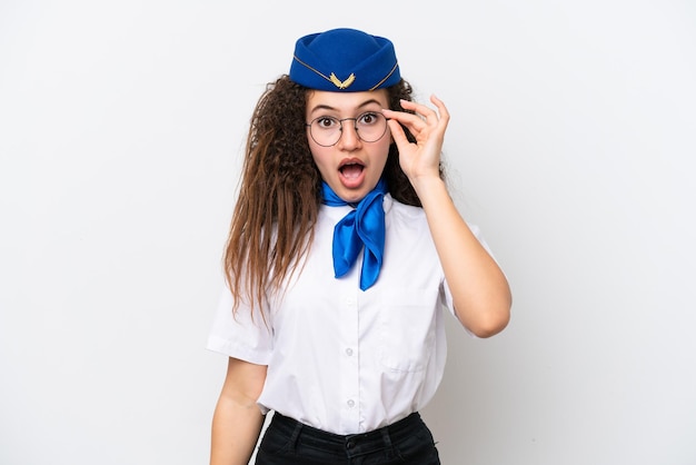 Airplane stewardess Arab woman isolated on white background with glasses and surprised