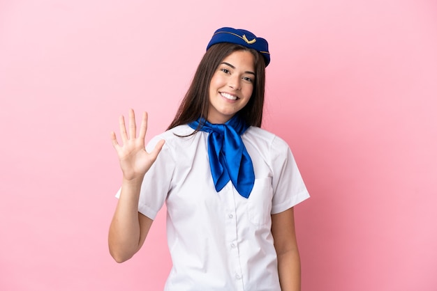 Airplane stewardess Brazilian woman isolated on pink background counting five with fingers