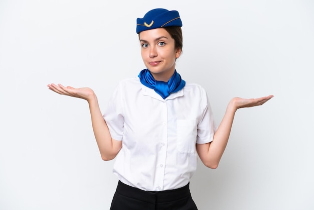 Airplane stewardess caucasian woman isolated on white background having doubts while raising hands