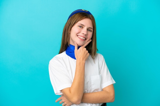 Hostess dell'aeroplano donna inglese isolata su sfondo blu sorridente
