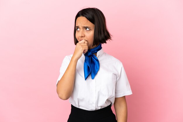 Airplane stewardess over isolated background having doubts and with confuse face expression