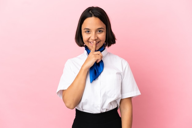 Airplane stewardess over isolated background showing a sign of silence gesture putting finger in mouth