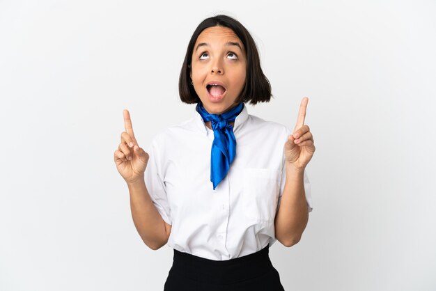 Airplane stewardess over isolated background surprised and pointing up