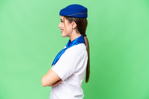 Airplane stewardess over isolated chroma key background in lateral position