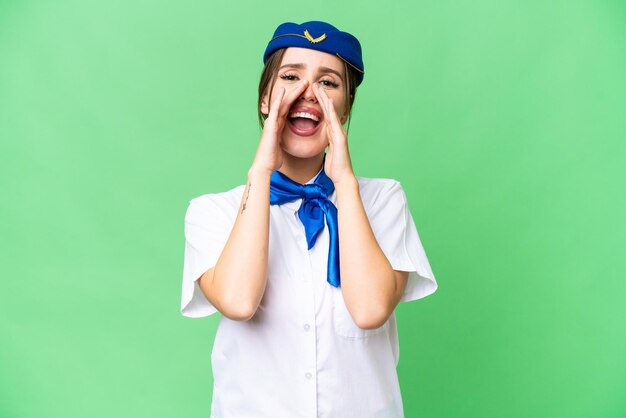 Airplane stewardess over isolated chroma key background shouting and announcing something