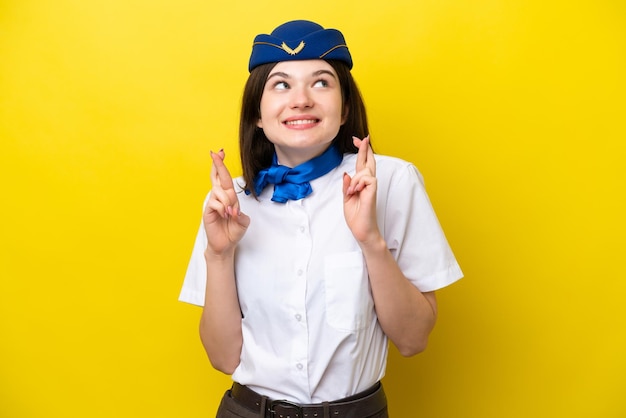 사진 비행기 스튜어디스 러시아 여성은 손가락을 건너 노란색 배경에 고립