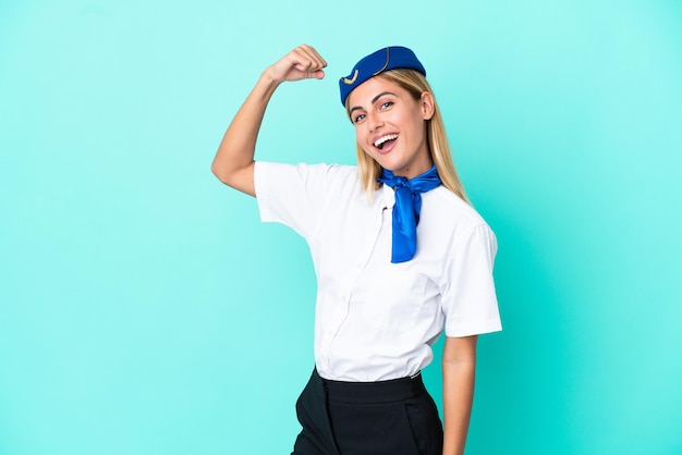 Hostess dell'aeroplano donna uruguaiana isolata su sfondo blu che fa un forte gesto