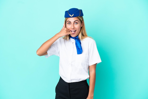 Foto hostess dell'aeroplano donna uruguaiana isolata su sfondo blu che fa il gesto del telefono call me back sign