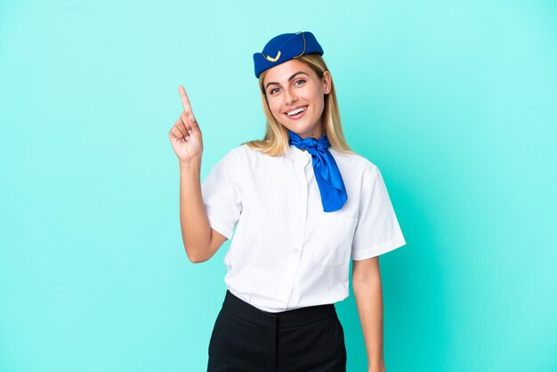 Airplane stewardess Uruguayan woman isolated on blue background showing and lifting a finger in sign of the best