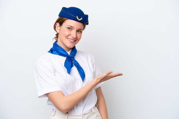 Donna hostess dell'aeroplano isolata su sfondo bianco che presenta un'idea mentre guarda sorridendo verso