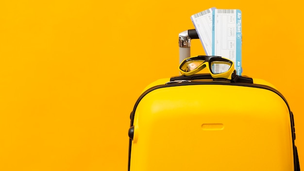 Airplane tickets on yellow luggage