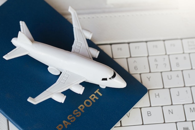 Airplane white laptop and passport Buying online ticket booking for travel concept