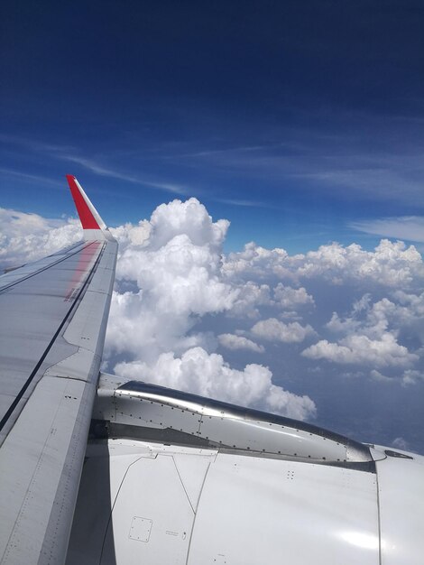 Airplane wing against cloudy sky