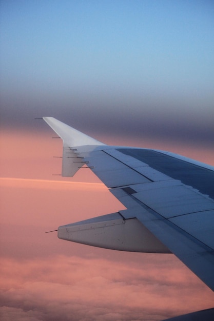 Крыло самолета на небе во время захода солнца