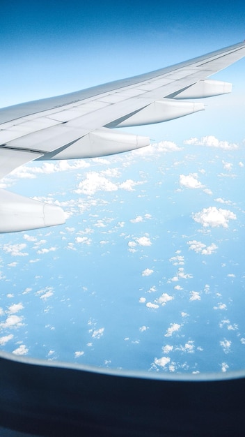 Airplane wing on blue sky with white clouds Travel concept